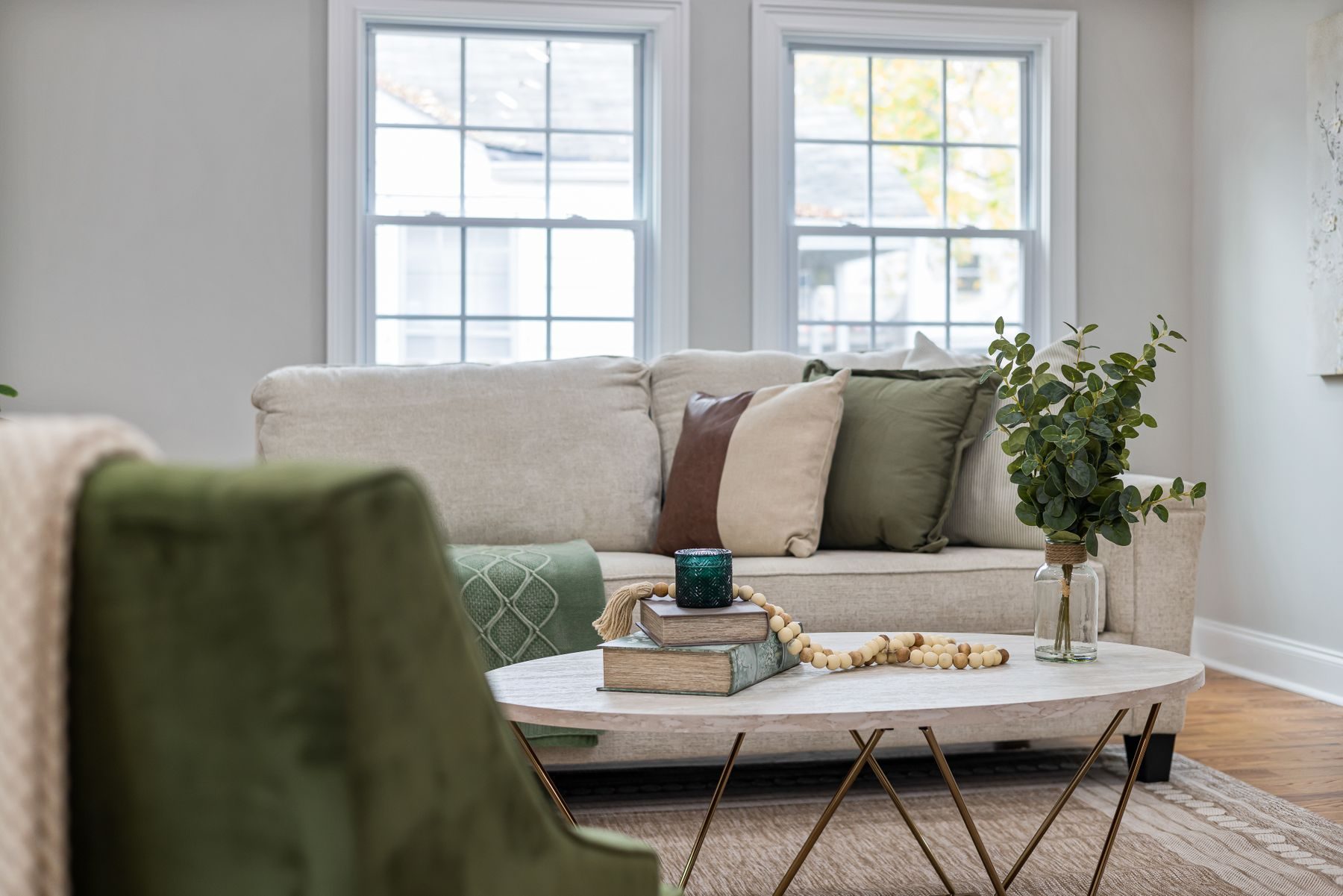 A sunlit living room furnished with a low linen sofa, oak coffee table and hand-loomed wool rug